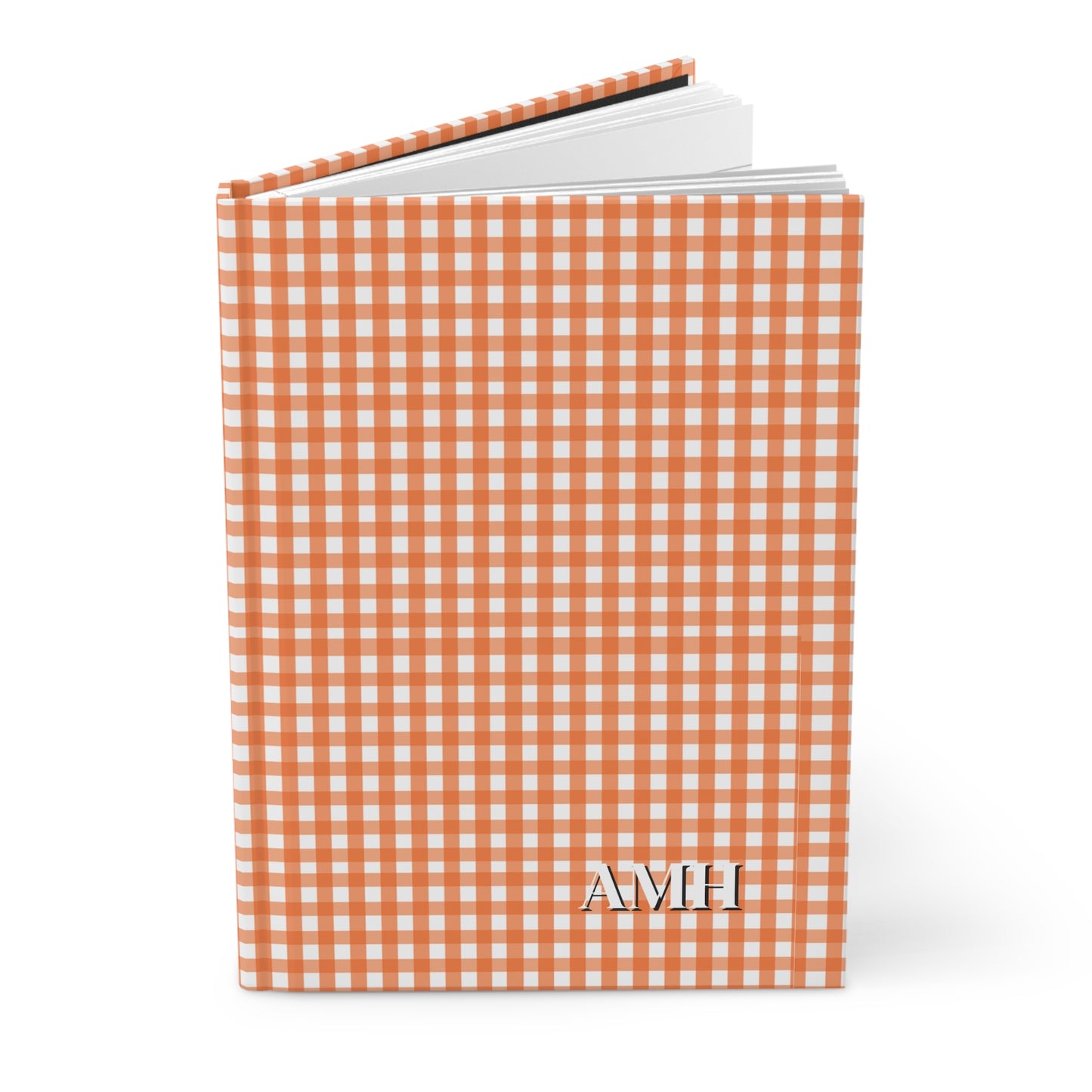 Notebook with orange and white checkered cover and 'AMH' monogram on a white background