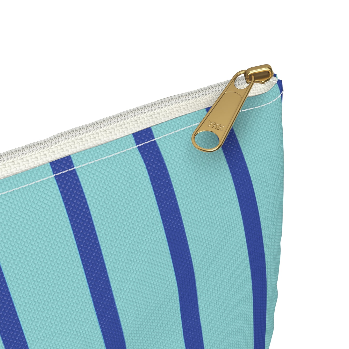 Close up view of gold zipper of mongrammed cosmetic bag with turquoise and blue vertical stripes