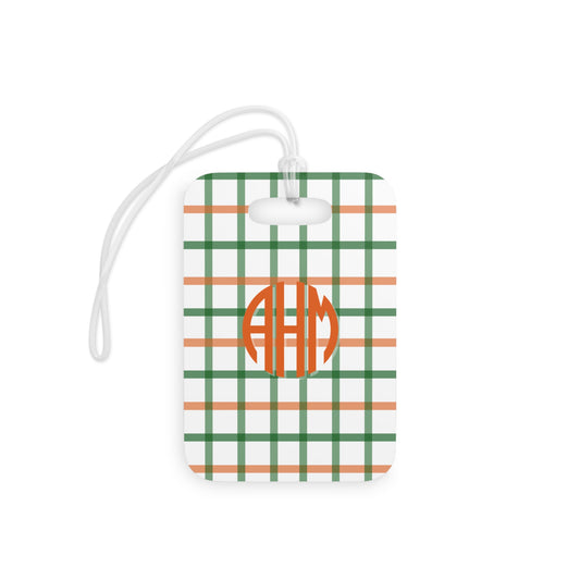 Luggage tag with green and orange plaid pattern and monogram on a white background