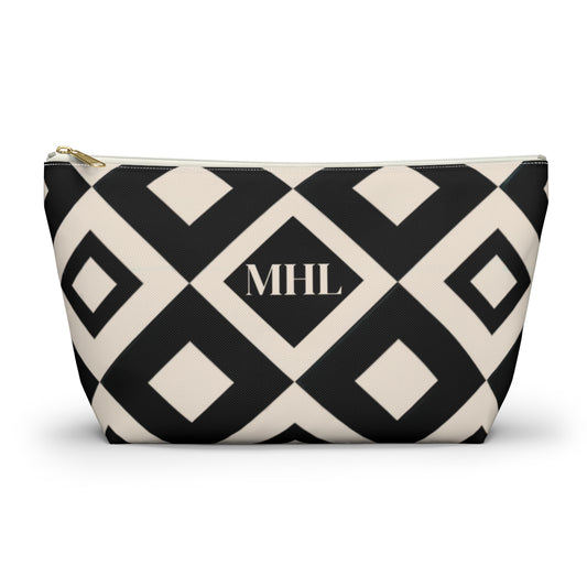 Monogrammed cosmetic travel bag in a repeating black and cream diamond pattern with white and gold zipper