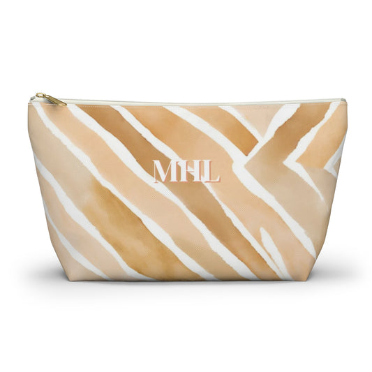 monogrammed cosmetic travel bag in a light tan, apricot  and cream abstract pattern with white and gold zipper