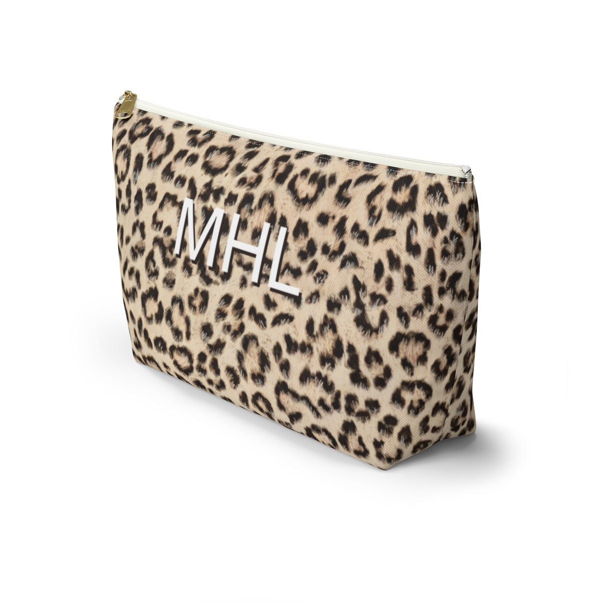 angled front view of personalized cosmetic travel bag with white monogram on cheetah print background