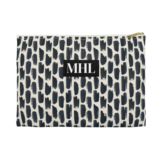 Personalized cosmetic travel bag with white monogram letters on a background of repeating abstract black and cream animal print design