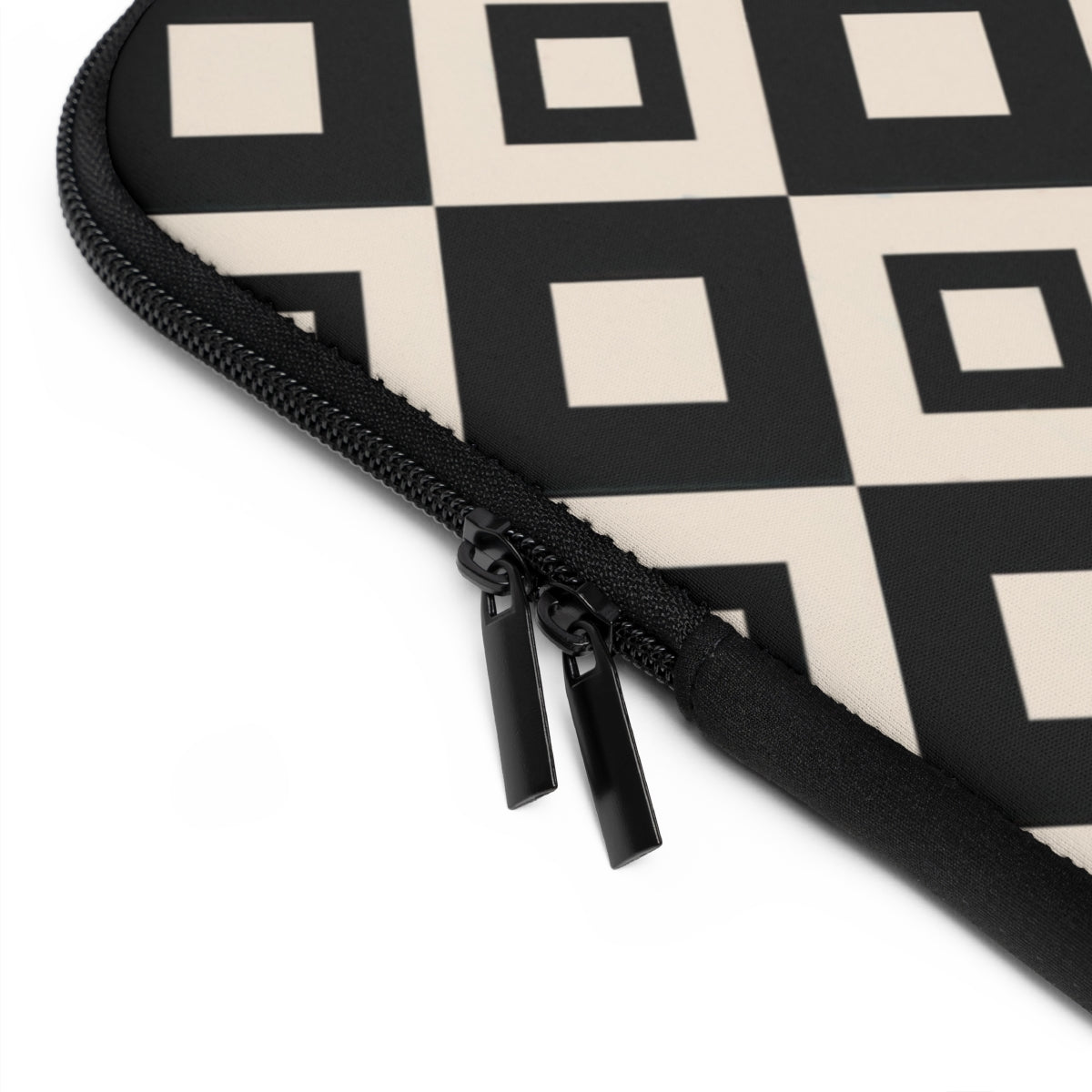 close up view of monogrammed  neoprene laptop case in a black and cream repeating diamond print