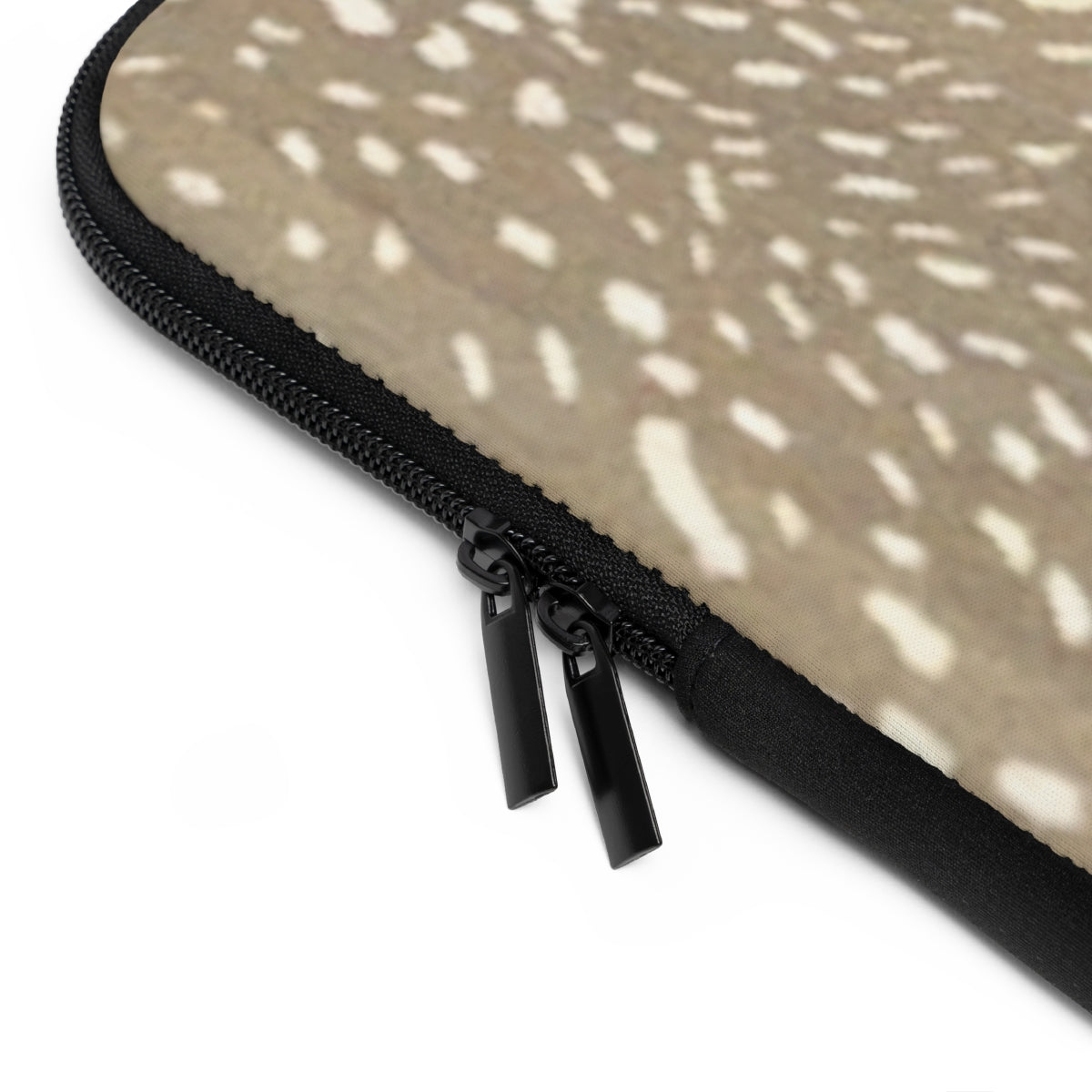 Close up view of zipper on neoprene personalized laptop sleeve with black monogram on a spotted deer print pattern background in brown and cream