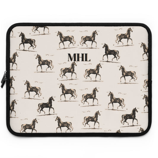 Monogrammed neoprene laptop case with a repeating pattern of horses on a cream background