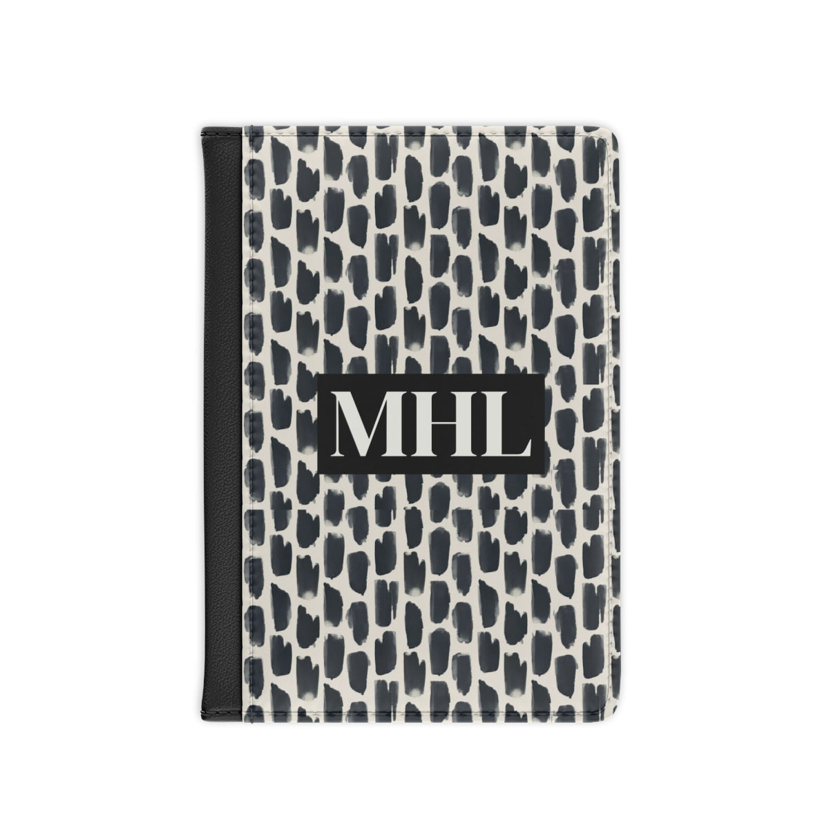 Front of personalized passport cover with a cream colored monogram on  a repeating abstract pattern of animal spots in black