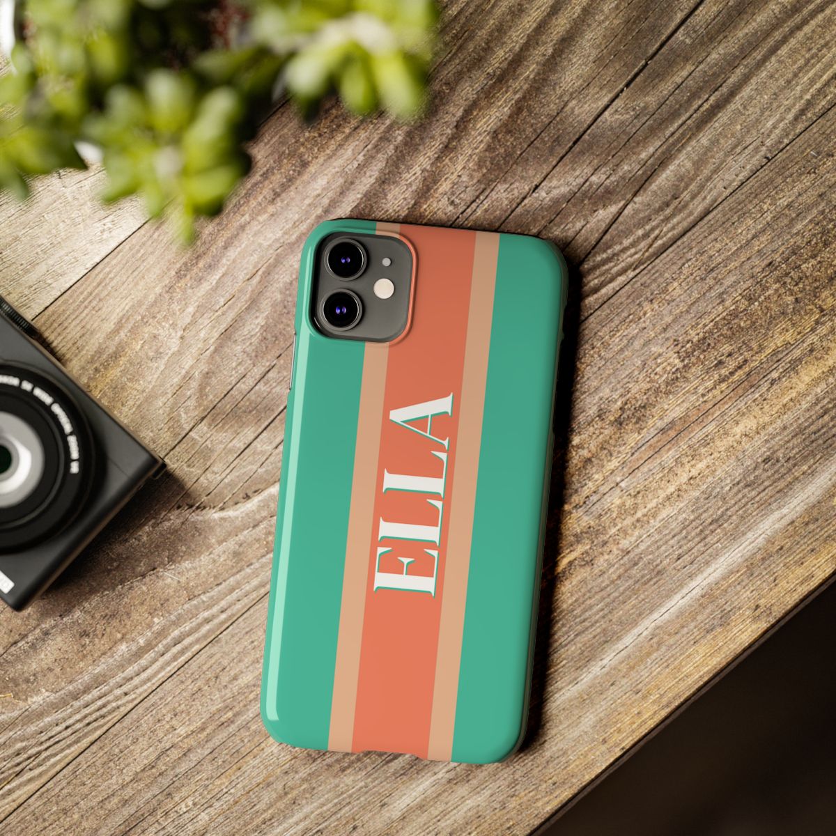 personalized iPhone case with white letters on a background of turquoise and coral vertical stripes