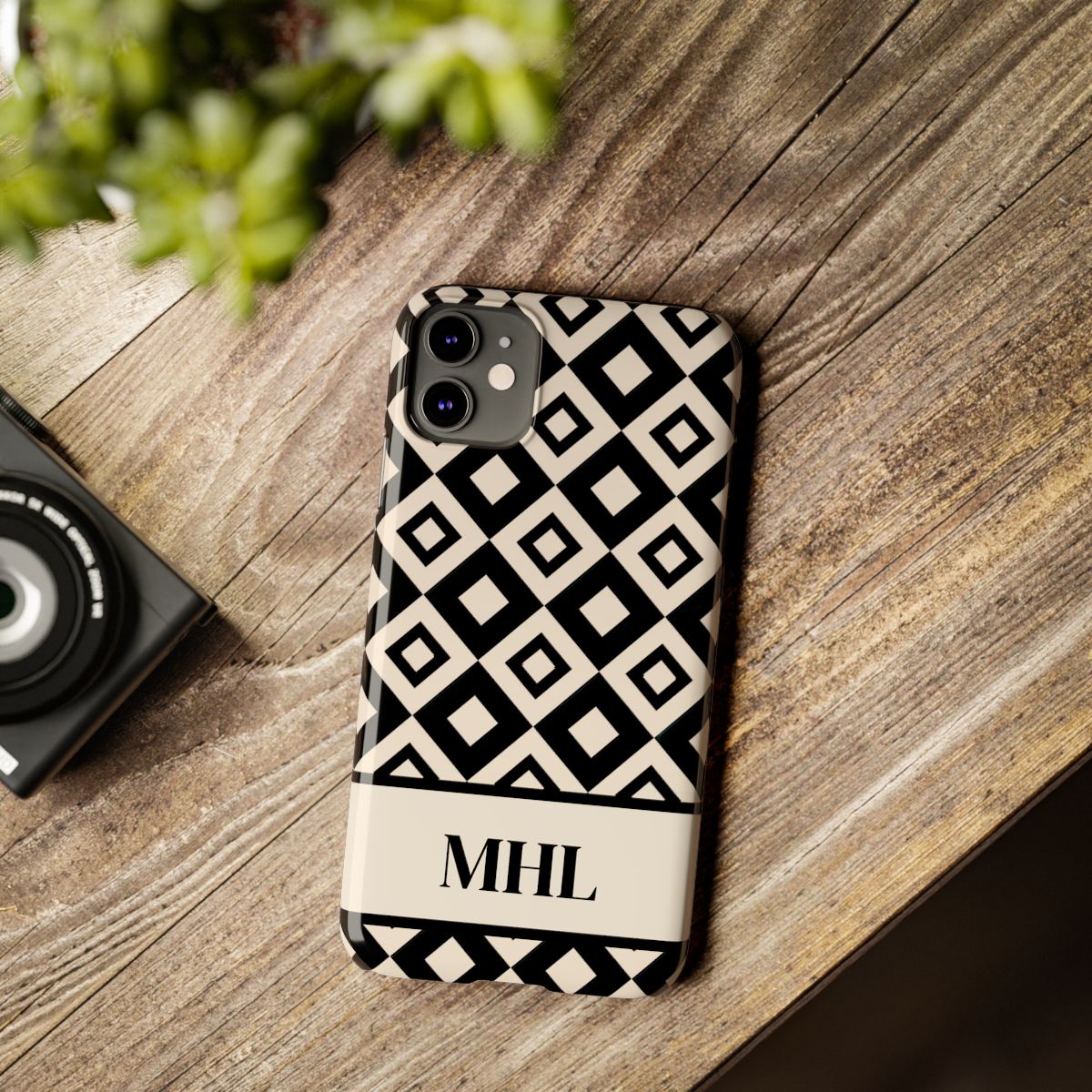 front view of personalized slim iPhone case with black monogram on a cream and black repeating diamond pattern background