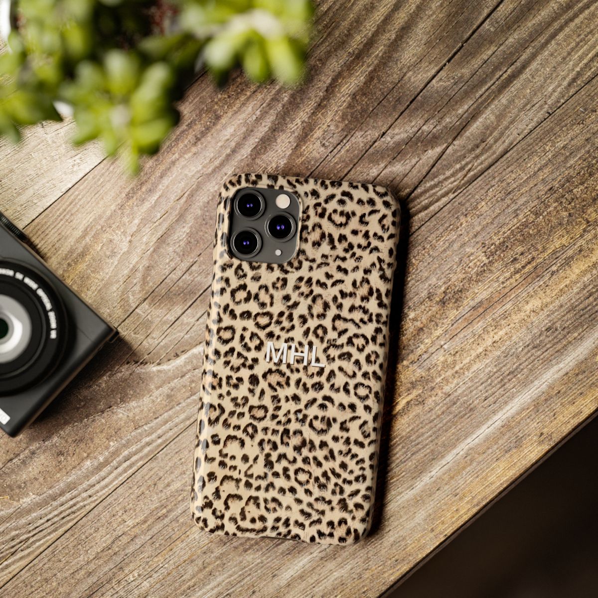 front view of personalized slim iPhone case with white monogram on a cheetah print background