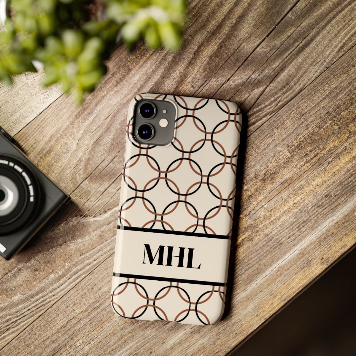 personalized slim iPhone case with black monogram on a cream background with repeating design of interlocking brown and black circles